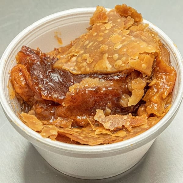 Close-up of a Maddie G's Chicken peach cobbler in a white to-go cup.
